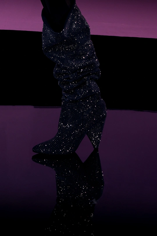 高跟鞋和靴子的一位女士站在舞台上 带着一把雨伞。