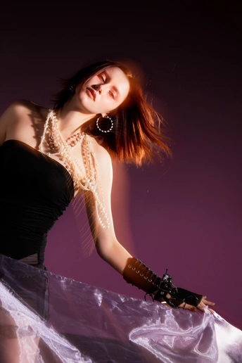 一位穿着黑色连衣裙和手套的年轻女子