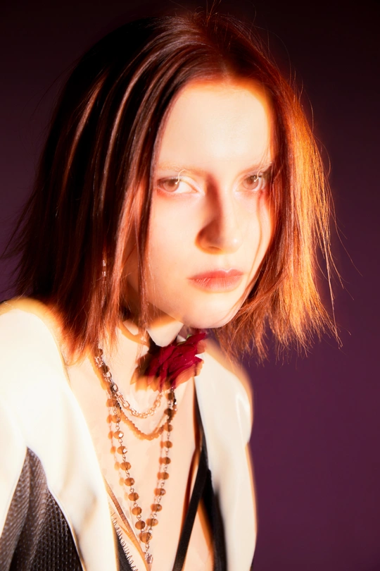 一位红发年轻女子穿着白色衬衫和黑色领带