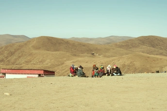 一群人在沙漠中的山顶上坐着