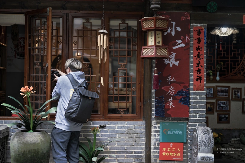 一个人站在一栋大楼前用相机拍照