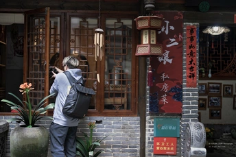 一个人站在一栋大楼前用相机拍照