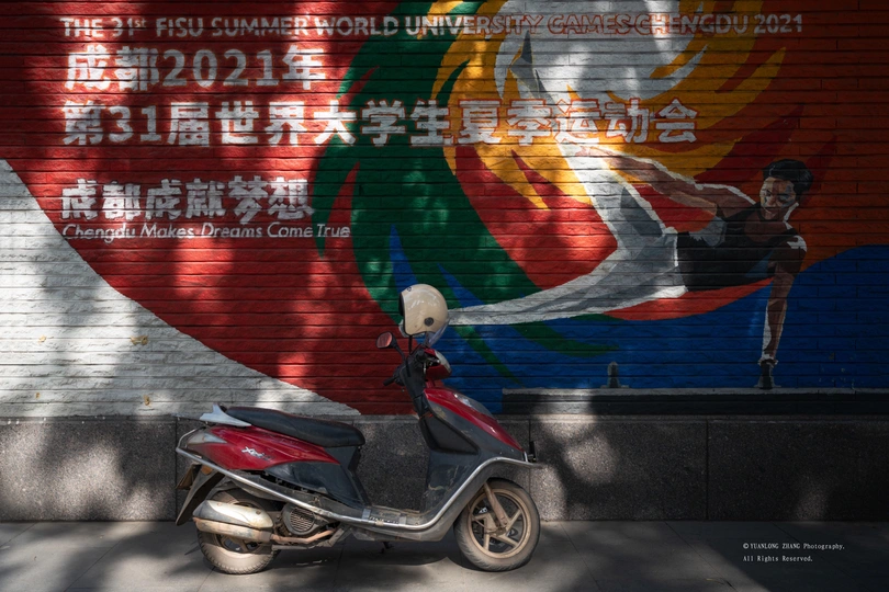 停在有壁画墙前的摩托车