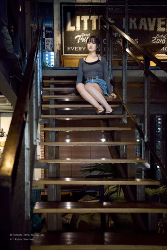 一位年轻女子坐在一些楼梯上