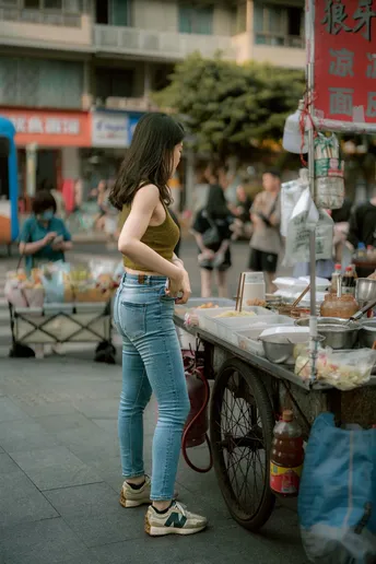 站在街上一辆食品车前的年轻女子