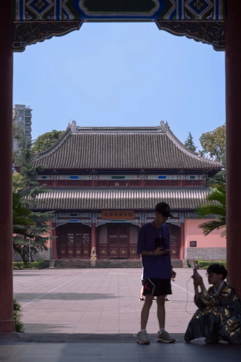 一些人在一个庭院里 在拱门下站着 背景是一座建筑。