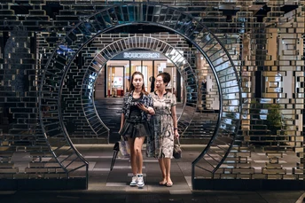 一位妇女和一位女孩站在镜子前