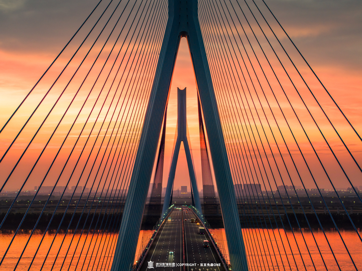 夕阳下横跨河流的漫长悬索桥