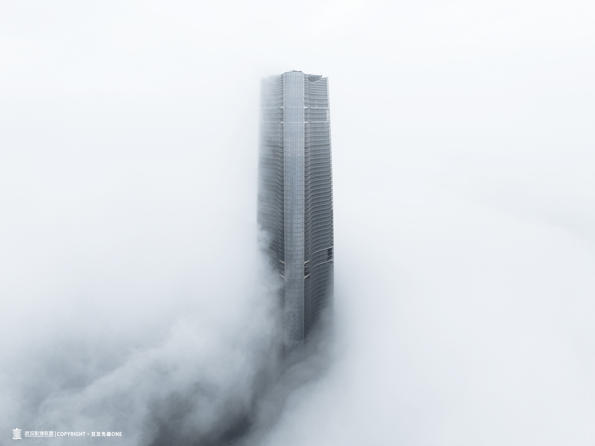 云中的雾气缭绕的城市中一座高楼的图片