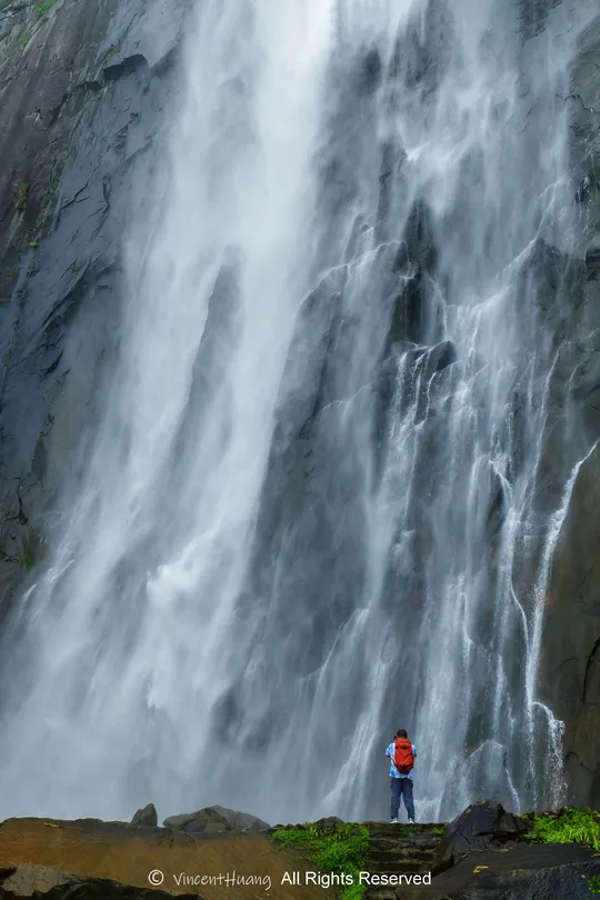 站在大型瀑布底部的一个男人