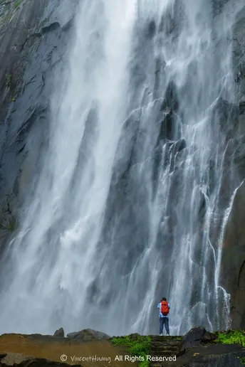 站在大型瀑布底部的一个男人