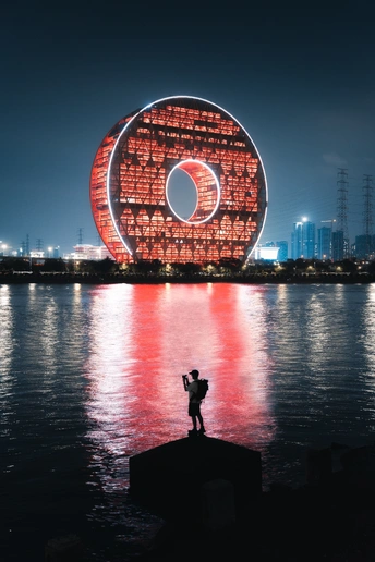 一个人站在水中 在夜晚拍摄一幅大型艺术作品。