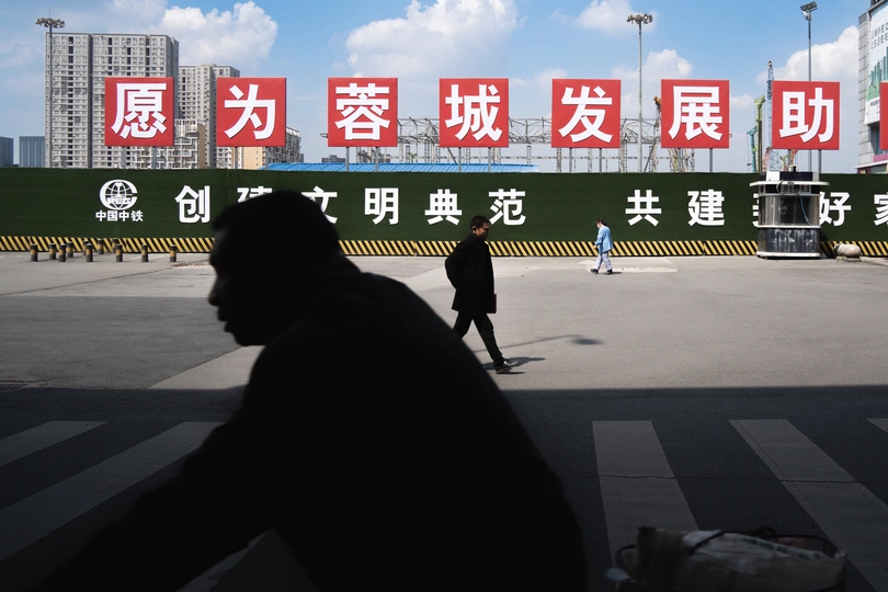 一个人穿越城市街道 背景有标志。