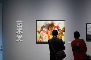 一个男性和一个女性站在艺术画廊里 注视着墙上的画。