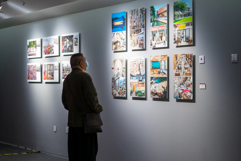 一个正在参观展览墙上艺术品的男子