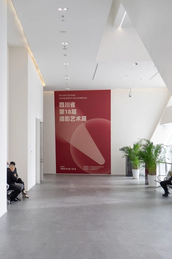 一个有大幅海报的墙壁和一个人们坐在椅子上的大厅