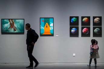 一个男子和一个女子站在艺术画廊里 注视着墙上的画作 此时一个孩子经过。