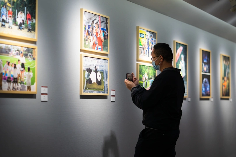 一个男子站在艺术画廊里 正看着墙上的画。