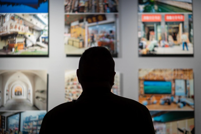 一个人站在房间里看着墙上的画