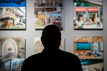 一个人站在房间里看着墙上的画