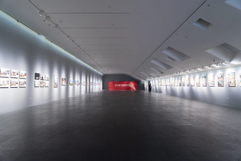 一条长走廊 墙壁是白色的 地板上有一个红色的灯。