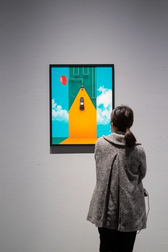 一位女士正在墙上看着一幅黄色的门画作。