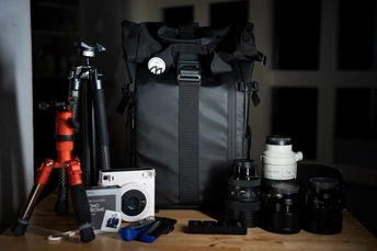 桌子上的一个相机、三脚架和包