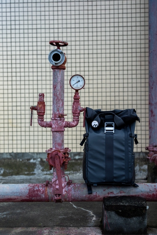 一个背包坐在红色的管道顶部