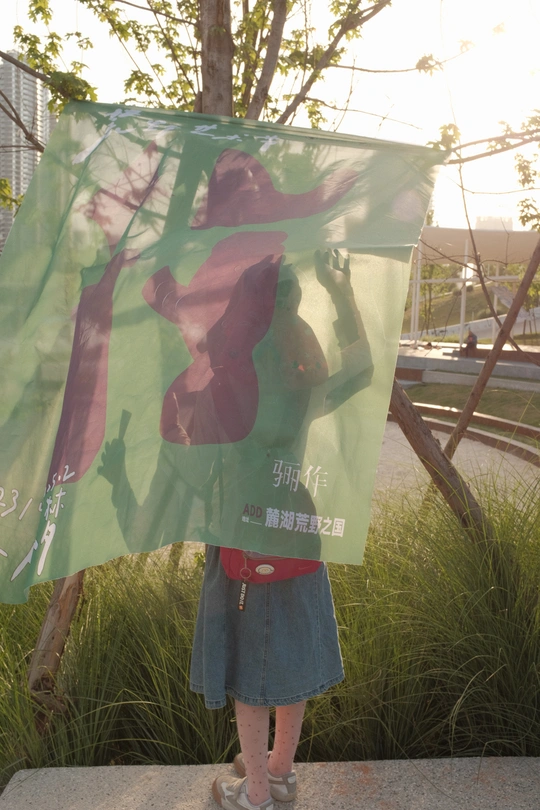 一个小女孩拿着一个带有女人站在雕像旁的图片的牌子