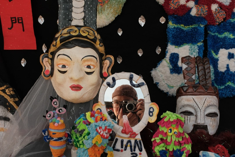 一位女士拿着相机拍摄一个蛋糕 蛋糕后面有一个新娘雕像。