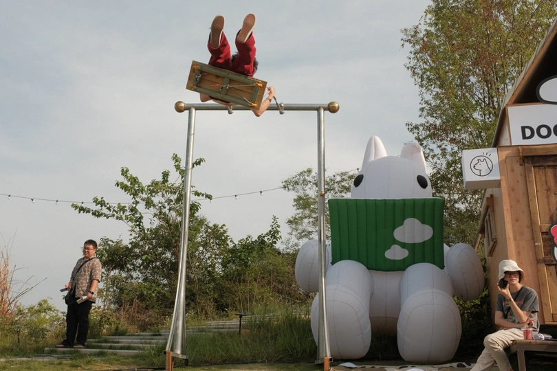 一个人坐在秋千上 旁边一个人坐在长凳上。