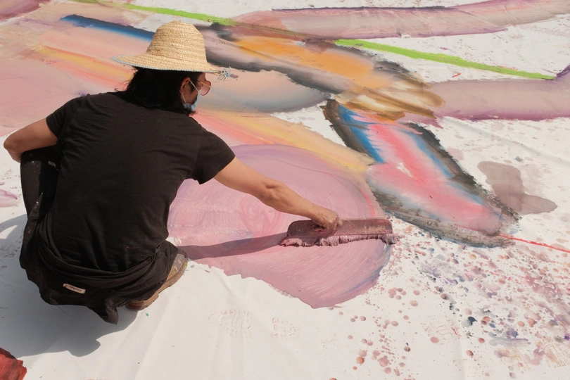 一个戴帽子的人在画一幅画 用颜料