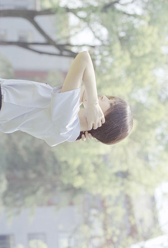 一个小女孩把双手背在身后 凝视着窗外的一个男孩。