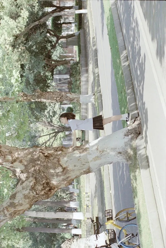 站在一棵树旁的建筑物旁边的人