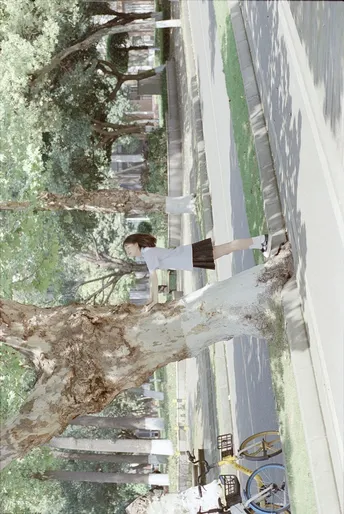 站在一棵树旁的建筑物旁边的人