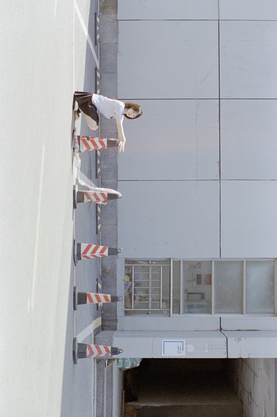 一个年轻人骑着滑板跳过一个建筑物的墙。