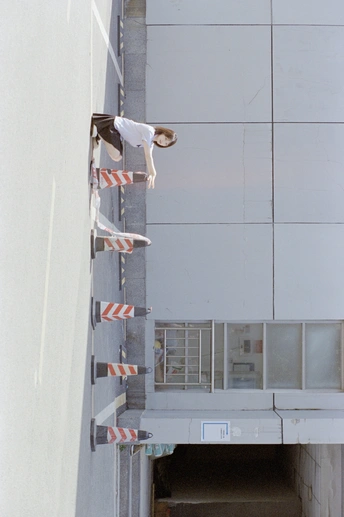 一个年轻人骑着滑板跳过一个建筑物的墙。