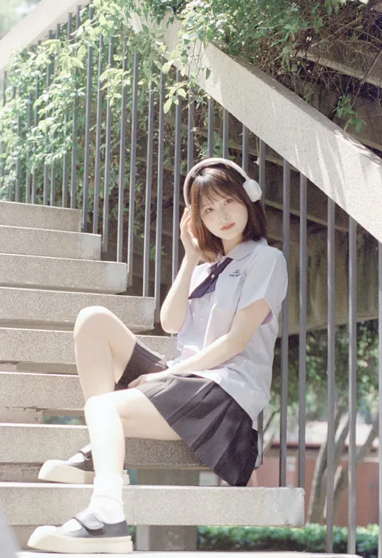一个穿校服的年轻女子坐在一些台阶上
