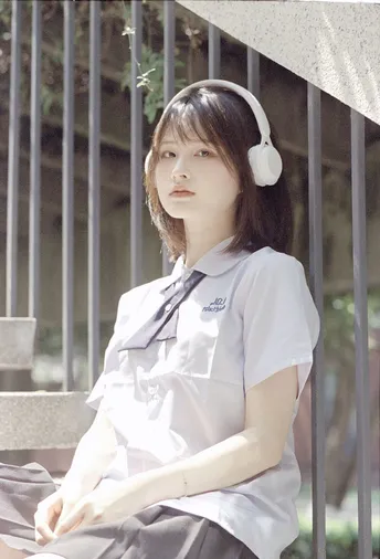 一位穿着白色制服的年轻女子坐在长凳上