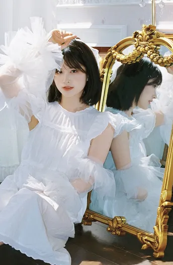 一位身着天使装的女子站在镜子前