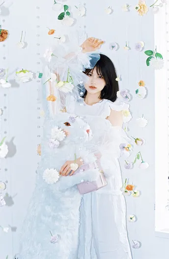 一位女孩在一个有白花墙的房间里