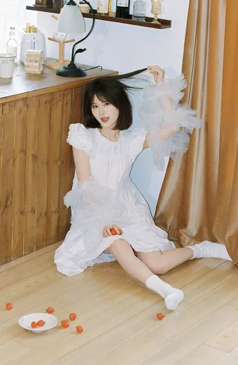 一个小女孩穿着白色裙子坐在地板上