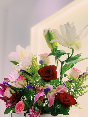 一个装满彩色花朵的白瓷花瓶放在桌子上