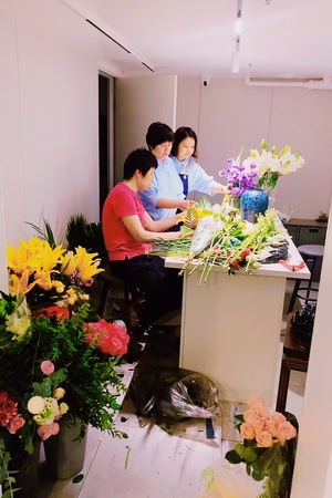 一个男子和一个女子坐在厨房的桌子旁 正在制作一束花。