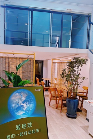 一个带有桌子和植物的大房间 位于建筑物内部。