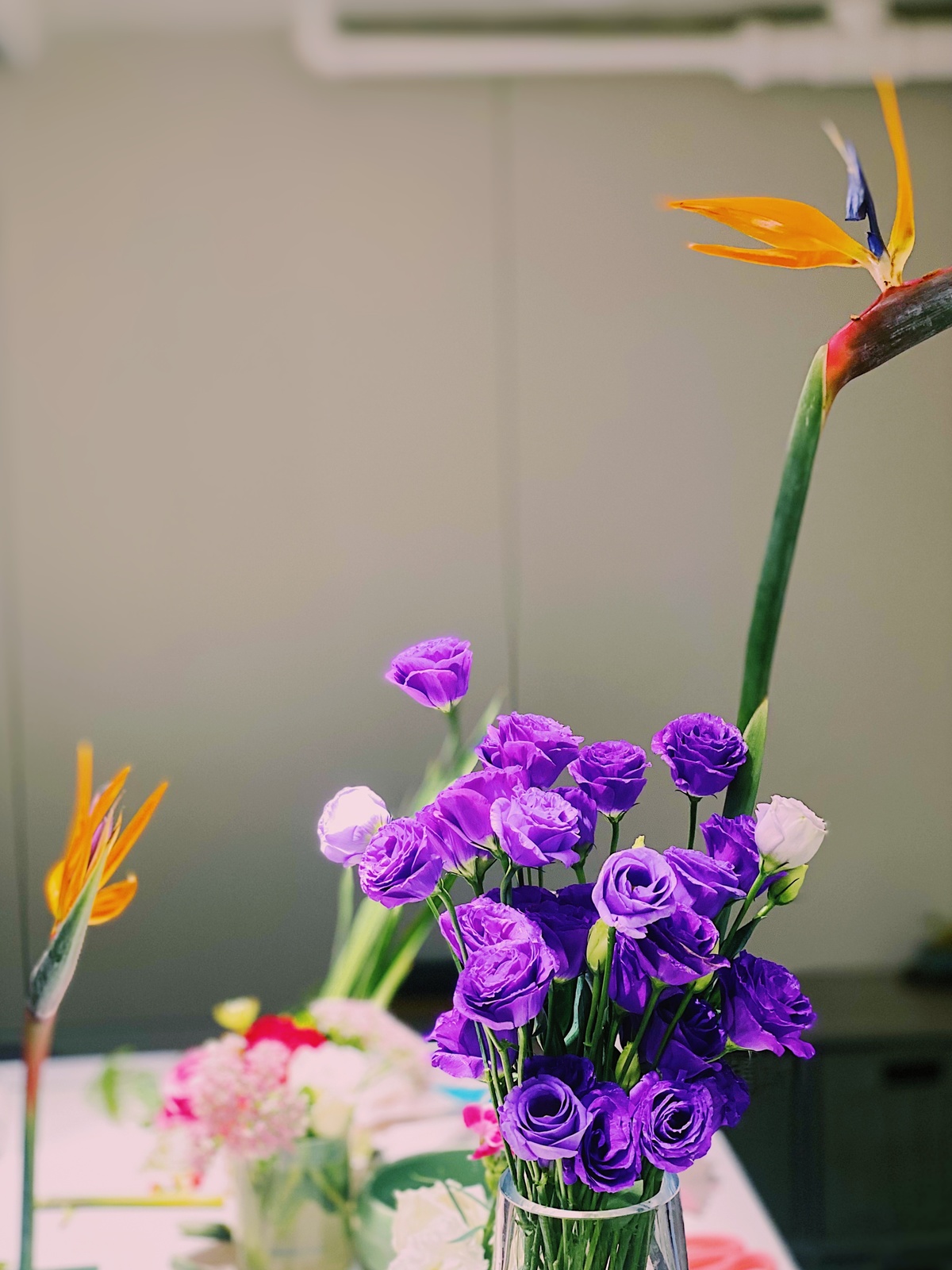 一个装满紫色花的透明花瓶 放在桌子上