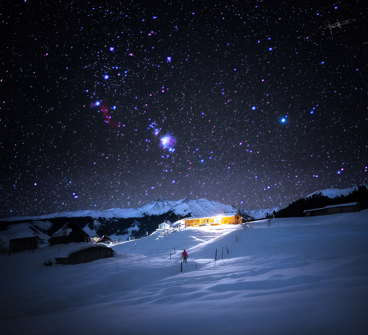 夜晚的雪山上有星星 房子被照亮了。