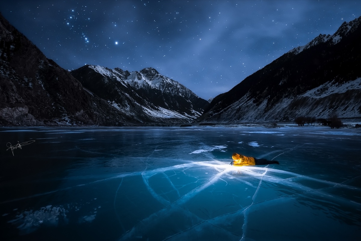 夜晚山中的一个结冰的湖 天空中繁星闪烁。