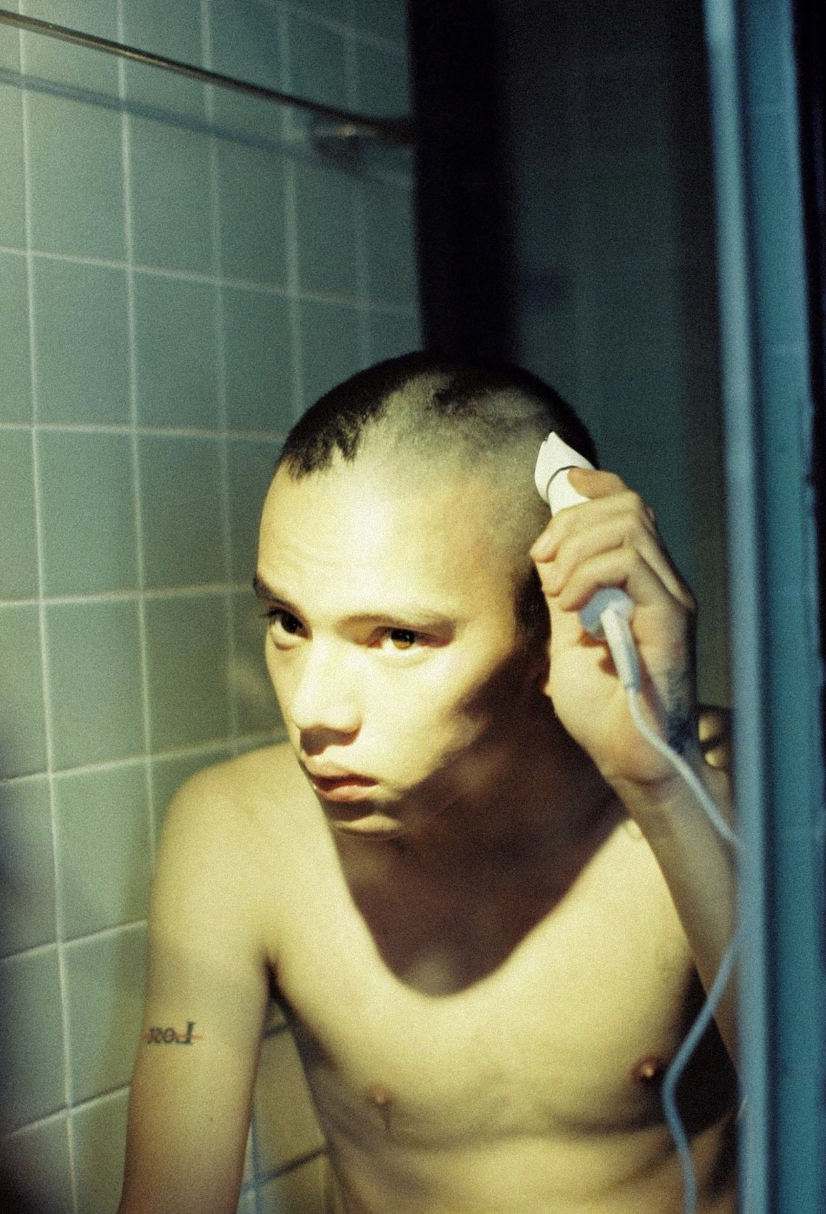 一个站在浴室镜子前梳理头发的年轻男子
