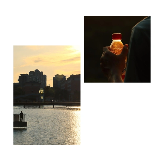 一位男子手里拿着一瓶饮料 背景是河上的落日 城市在背景中。